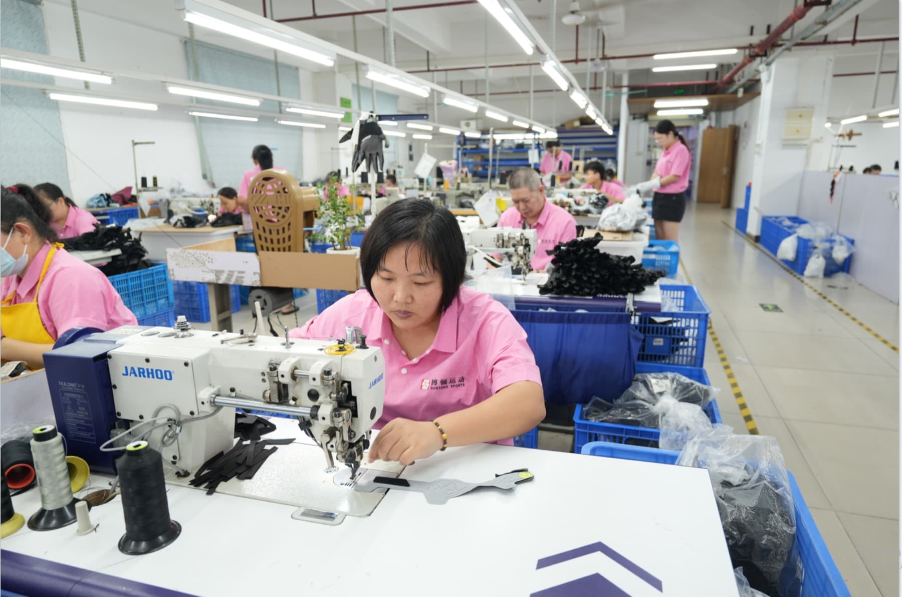 BURTONO production team sewing sports gloves in the workshop