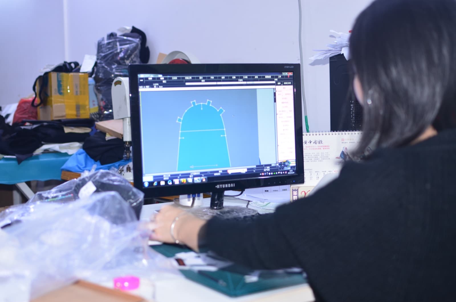 BURTONO pattern technician working on a glove panel at a computer workstation