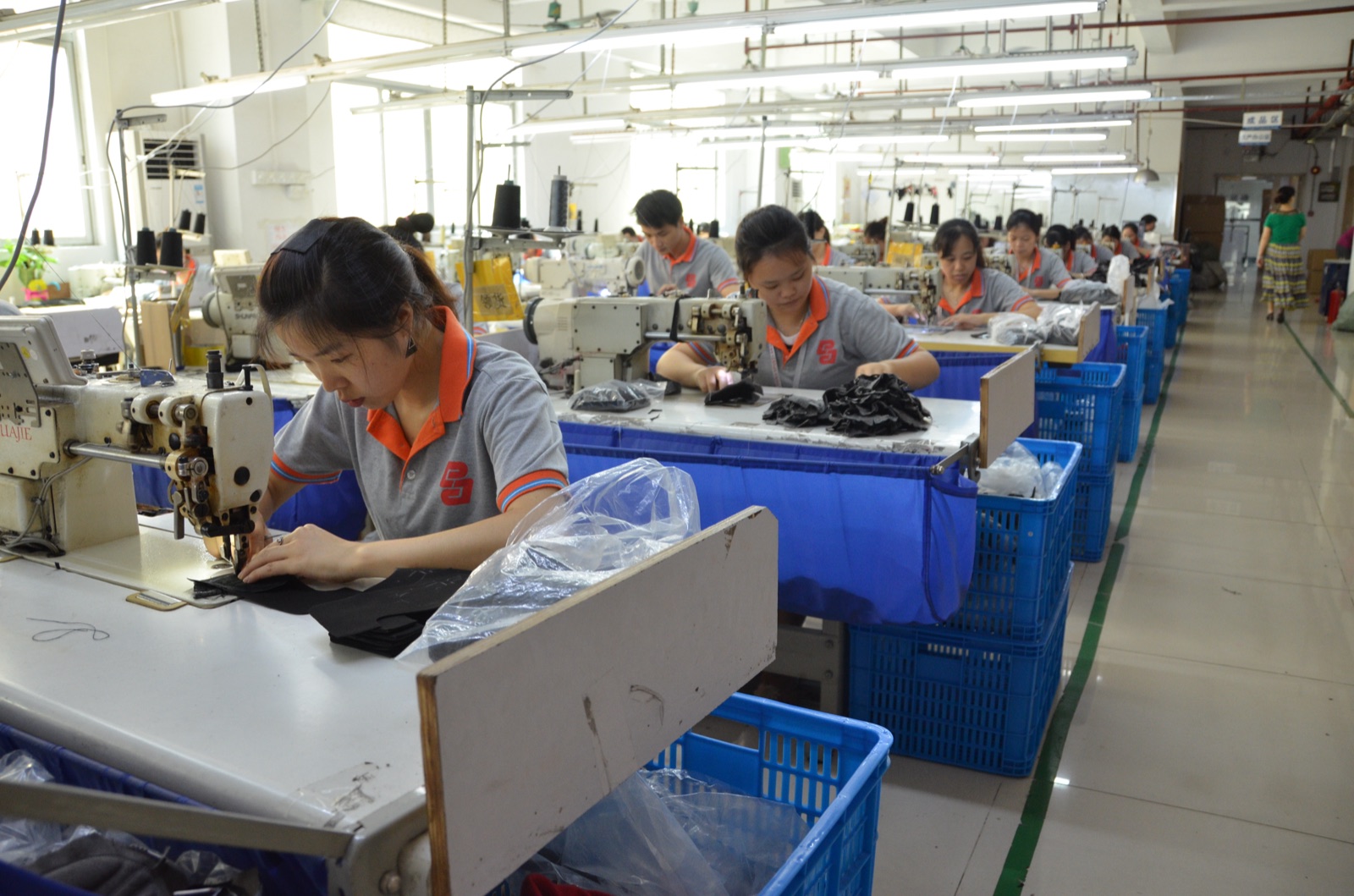 Production team sewing sports gloves at individual workstations